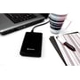 Sort Verbatim Store 'n' Go Slim Portable SSD tilsluttet en bærbar computer på et skrivebord med en stribet kop og notesbog.