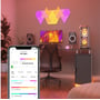 Nanoleaf Shapes Triangles lyspaneler skaber et farverigt lysdesign i et moderne stuemiljø med computermøbler.