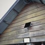 V-TAC 10 W solcelle-LED-projektør monteret på en trævæg med solpanelet placeret ovenover.