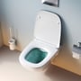 AM.PM X-Joy toiletsæt med åbenstående hvid toiletkumme, der viser den grønne vandfyldte kumme og toiletsædet.