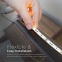 Hånd der monterer V-TAC LED stribe på et bord, med tekst om 'Flexible & Easy Installation' og kobberstrip for ledningsevne.