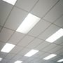 Flere V-TAC LED paneler monteret i et akustikloft i en kontorbygning, der giver jævn belysning.