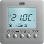 Nærbillede af ABB KNX rumtermostat i sølv, viser de fire runde knapper og et LCD-display med temperatur og statusikoner.