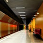 V-TAC LED-armaturer monteret langs loftet i en oplyst gang med farvede vægge og bænke.