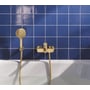 Grohe Lineare kar-/brusearmatur i børstet cool sunrise monteret ved et badekar med håndbruser mod blå fliser.