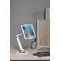 Deltaco universal tabletbordstander i hvid, der holder en tablet på et skrivebord med en laptop og mobiltelefon i baggrunden.