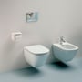 Laufen LUA hængeskål i hvid porcelæn med rimless skyl og skjult montering ved siden af et bidét på en lys væg.