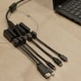 Deltaco HDMI adapterring forbundet til en bærbar computer via USB-C-porten, vist på et træbord.