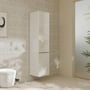 Hansgrohe Xelu Q højskab i hvid højglans monteret på en væg i et badeværelse ved siden af et toilet og en plante.
