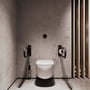 To sorte Nichba toiletstøtter er monteret på hver side af et toilet, og papirholderen ses til højre.