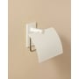 Cosmic toiletpapirholder med låg i mat hvid monteret på en lys beige væg, viser dens diskrete design og praktiske funktion.