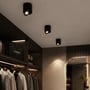 Tre sorte V-TAC 12 W LED-påbygningsspots er monteret i loftet og lyser op i en tøjbutik.