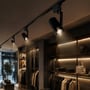 V-TAC 30 W 3-faset skinnespot monteret på en skinne og oplyser varer i en tøjbutik.