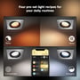 Fire Philips Hue Centura spots i forskellige nuancer af hvidt og gult lys, vist med tilhørende scener i en app: Relax og Read.
