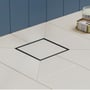 Hansgrohe afløbsskål i børstet rustfrit stål med en ramme på 100 x 100 mm, monteret i et cremefarvet flisegulv med mørkeblå vægpaneler bagved.