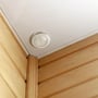 Diskret installation af V-TAC PIR loftsensor i et træbeklædt loft i et hjørne af et rum.