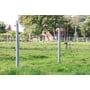 Hanit rund plastpæl i grå, monteret som hegnspæl med tråde på en grøn mark ved en gård.