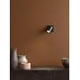 Astro Lighting Ascoli Single spot i mat sort er monteret på en brun væg over et møbel med keramik.