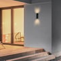 V-TAC LED væglampe Vt-91008 monteret på en husmur ved en træterrasse, lyser op og ned.