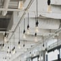 Videx ST64-filament LED-pærer hænger fra sorte fatninger i et lyst lokale og giver et varmt skær.
