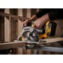 DeWalt 18V XR rundsav DCS565N-XJ skærer i en træplanke med batteri monteret i et træværksted.