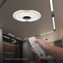 Hånd der holder fjernbetjeningen til V-TAC 95W LED smart loftlampen, demonstrerer fjernstyringsfunktionen.