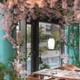 SLV Pantilo Oval PD pendellampe i hvidt glas med krom detaljer, monteret i en hyggelig restaurant med kirsebærblomstdekorationer.