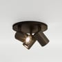Astro Lighting Ascoli Triple Round spotlampe i bronze set monteret mod en lys flade med de tre spotarme rettet forskelligt.