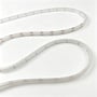 Den klare, fleksible RGB COB-LED-strip ligger i store kurver og viser gentagne markeringer langs kanten.