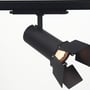 Sort 30 W 3-faset DALI-dæmpbar skinnespot monteret på skinne med klapper og tændt lyskilde.
