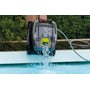Swim & Fun Zodiac Robot GT3220 poolrobot løftes op af poolen, mens vand sprøjter fra den, med en hånd der holder i håndtaget.