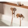 Grohe Lineare kar- og brusearmatur i warm sunset-kobber monteret ved badekar, vist sammen med håndbruser.