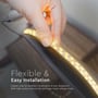 Nærbillede af en hånd der monterer en V-TAC LED strip, der fremhæver dens fleksibilitet og klæbeevne.
