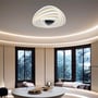Den dekorative V-TAC LED loftlampe monteret i et moderne loungeområde med store vinduer, hvilket viser dens stilfulde design og atmosfæriske lys.