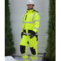 Lyngsøe Rainwear vinterbukser full stretch i hi-vis gul og sort, str. L, ses på en person i vinterligt arbejdsmiljø.
