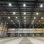 Industrielt loft med et stort antal V-TAC 200W LED UFO Highbay armaturer installeret for kraftig belysning.