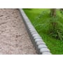 Hanit palisader som kant langs græsplæne og et grusområde, med fokus på den runde top og indhak.