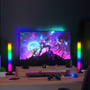 To 32cm RGBIC ambient light bars flankerer en computerskærm på et gaming-skrivebord, der skaber et dynamisk lysmiljø.