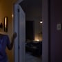 Philips Hue bevægelsessensor diskret placeret ved en døråbning til et soveværelse, aktiverer lys ved indtræden i mørket.