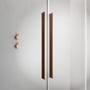 Detalje af håndtag og glaskant på Strømberg Faro 22 skydedør til niche med børstet kobberfinish.