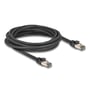 Sort Delock RJ45 Cat.6A netværkskabel på 5 meter, viklet sammen og vist med begge afskærmede RJ45-stik.