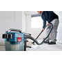 Bosch GAS 18V-10L Professional-støvsuger suger vand op fra gulvet, mens en person fører slangen hen over det våde område.