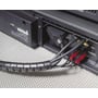 HellermannTyton Helawrap spiralslange i sort, 25 mm, bundter audio/video kabler til en elektronikenhed, viser fleksibilitet.