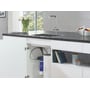 GROHE Red II Duo køkkenarmatur med L-tud er monteret ved en køkkenvask, med kedel og filter i skabet nedenunder.