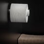 Cosmic toiletpapirholder uden låg i mat hvid, viser en rulle toiletpapir monteret på en minimalistisk holder i et mørkt badeværelsesmiljø.