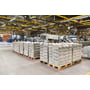 Philips CoreLine All-in WT120C Gen3 industriarmaturer lyser op under loftet i en stor produktionshal.