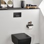 Villeroy & Boch ViConnect E300 betjeningsplade monteret på væggen over et sort toilet i et lyst badeværelse.