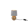 Sophia bordlampe fra TRIO Lighting i gylden keramik med grå stofskærm og afbryder på sort ledning.
