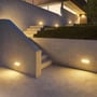 V-TAC LED-landskabsbelysning på 12 W lyser op langs udendørs betontrapper og havemure ved en bygning.