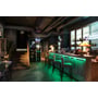 Moderne bar med grøn belysning fra Ansell Lighting E-Cell Eco RGB LED bånd under bardisken og langs gulvet.